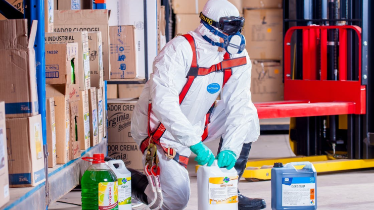 A professional worker checking on chemicals before pressure washing