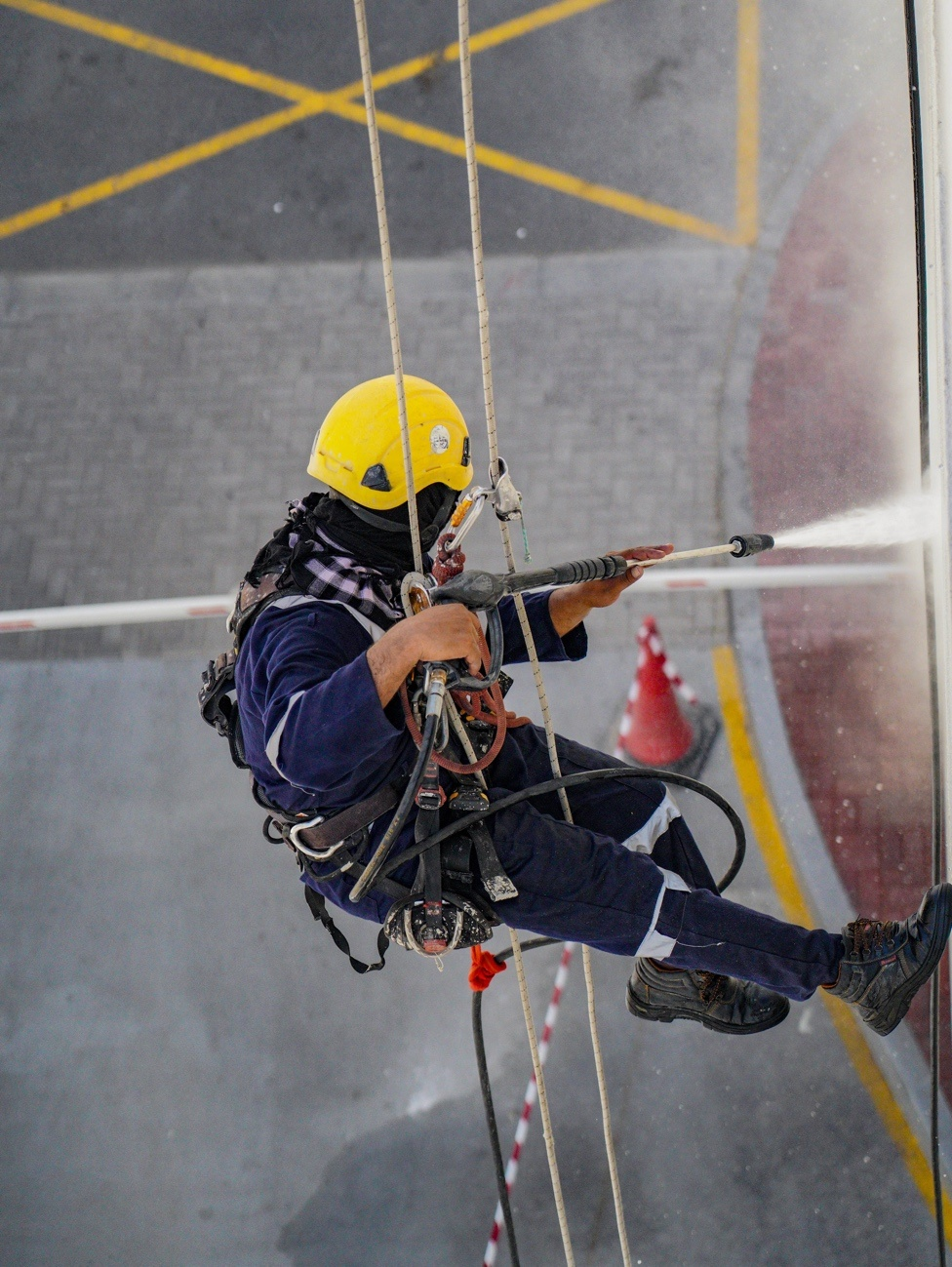 A professional pressure washing a window