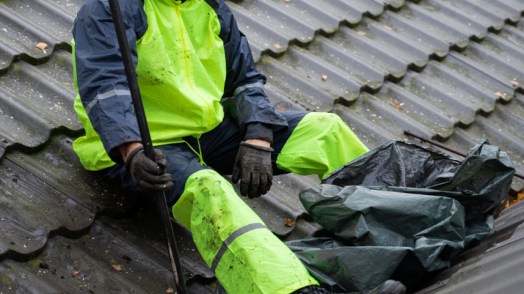  A man providing roof moss removal service